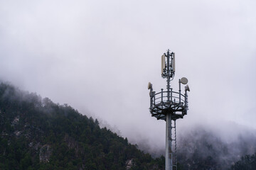 Close-up of a communication tower in the mountains against the backdrop of a mountain forest...