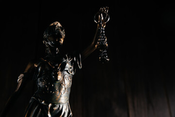 Lady Justice close-up in a dark court room