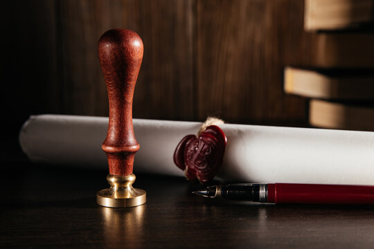 Notary's public pen and document with wax stamp at wooden desk close-up