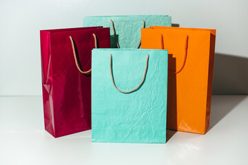 Four colored crumpled pink, orange and blue gift paper bags on a white background. Holiday, gifts,...