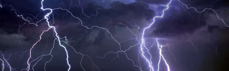 Fork lightning striking down during summer storm - 504268085