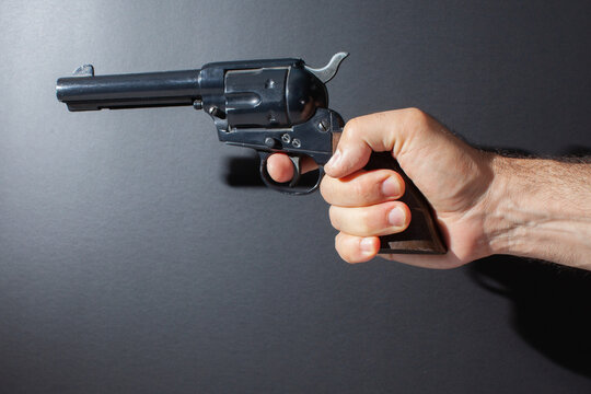 hand holding replica gun isolated on dark background