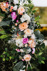 Element, part of a wedding arch in colorful flowers, roses, green leaves. Festive photo of decorations.