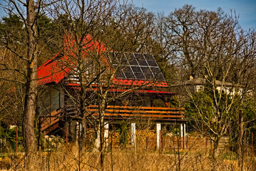 Dom w podmiejskiej okolicy na przedmieściach . Panele słoneczne na dachu domu . Wczesną wiosną