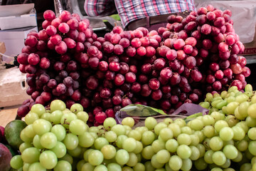 Racimos de uvas rojas y verdes frescas, en un puesto del mercado en México. Latinoamérica.