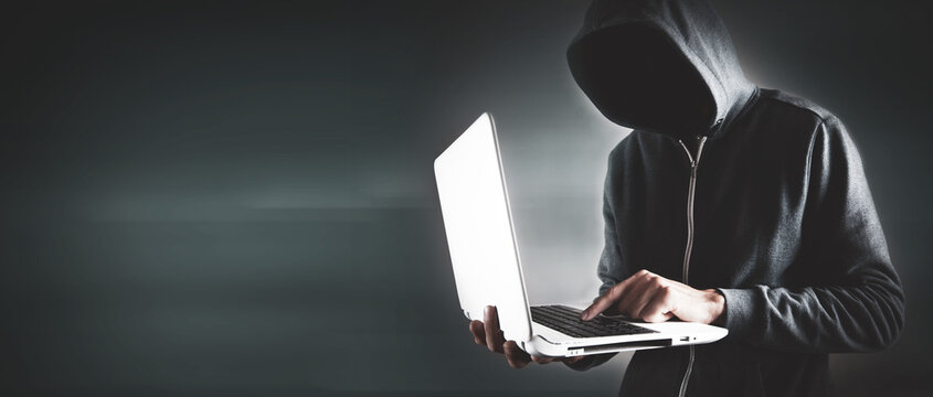 Hacker with laptop. Computer crime.