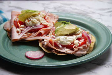 Ham tostadas with cheese and avocado. Mexican food