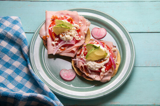 Ham tostadas with cheese and avocado. Mexican food