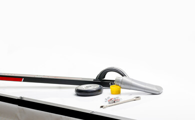 White table ski service. On the table is a roller skier with the wheel removed, a tube of lubricant, a new wheel, keys and bearings