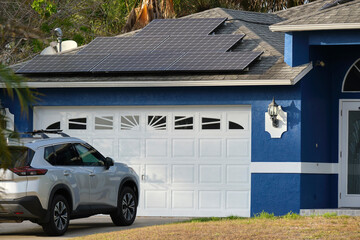 Car parked in front of wide garage double door on concrete driveway of new modern american house