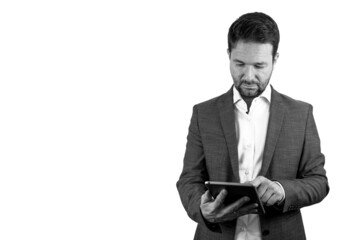 Black & White. Handsome middle-aged businessman, wearing suit, uses a tablet. Pure white background. Copyspace.	
