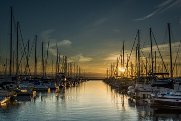 Fototapeta na wymiar Sunset over ships moored at Shilshole Bay Marina, Ballard, Seattle, Washington
