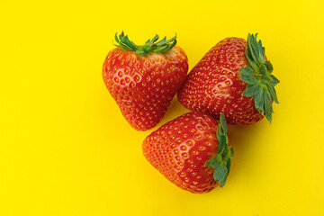Fresh strawberries on a yellow background. Top vantage point.Summer vivid photo