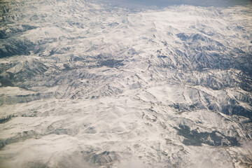 Aerial view of snowy mountains with clouds