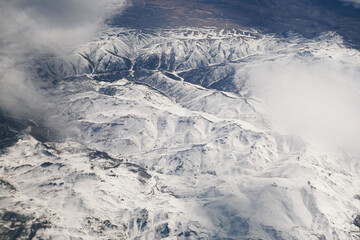 Aerial view of snowy mountains with clouds