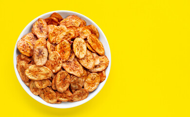 Banana slice chips on yellow background.