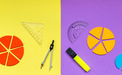 Multicolored fractions, rulers, pencils on a yellow violet background. Interesting, fun math for...