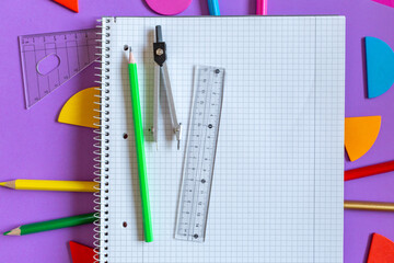 School supplies, open notepad, rulers, fractions on a violet background. Interesting, fun math for...