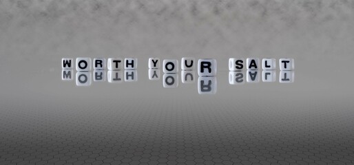 worth your salt word or concept represented by black and white letter cubes on a grey horizon...