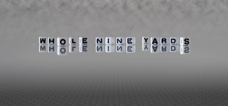 whole nine yards word or concept represented by black and white letter cubes on a grey horizon background stretching to infinity