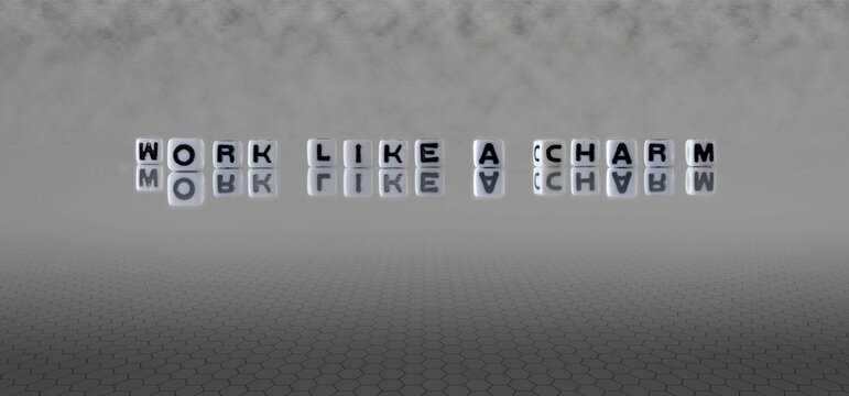 work like a charm word or concept represented by black and white letter cubes on a grey horizon background stretching to infinity