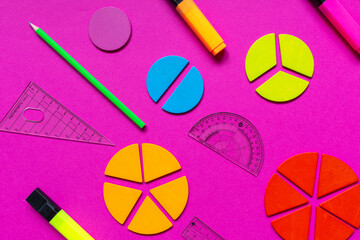 Multicolored fractions, rulers, pencils on a magenta pink background. Interesting, fun math for...