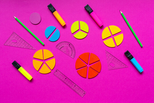 Multicolored fractions, rulers, pencils on a magenta pink background. Interesting, fun math for kids. Education, back to school concept