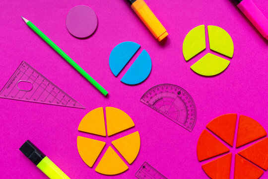 Multicolored fractions, rulers, pencils on a magenta pink background. Interesting, fun math for kids. Education, back to school concept