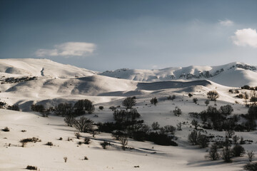 Landscape view of a mountain with snow, blue sky and some clouds