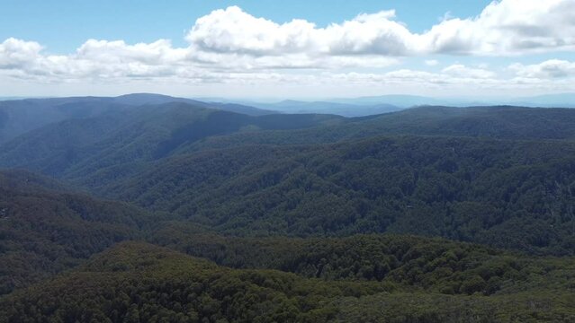 Slow drone dolly in to rolling mountains in the Victorian high country in Mt Buller