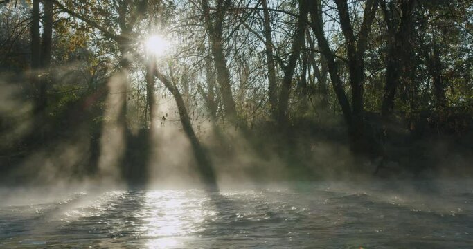 The morning sun rises over the Lambro river in Italy in autumn in a mystical and magic moment