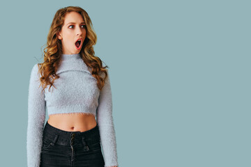 portrait of young shocked woman with long curly hair studio