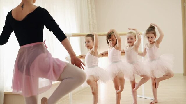 Woman teaching young ballerinas the art of dance