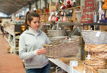 Female customer choosing wicker products in home decor warehouse