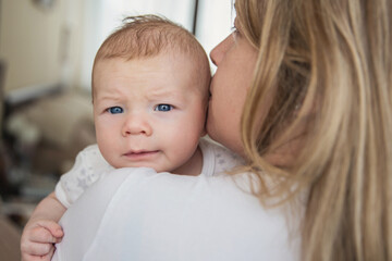 Blue-eyed baby hugging his mother