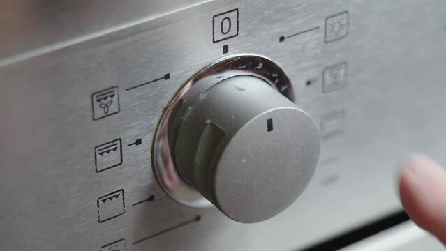 Metallic Toggle Switch of the Cooker Oven Close-up. Front panel of modern oven. Switching on the stove, baking oven and changing modes in order to preheat and cook meal. High quality 4k footage