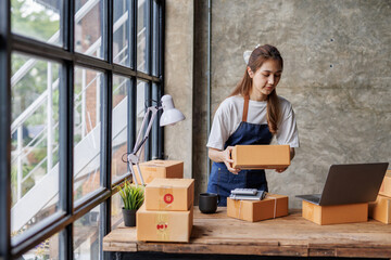 Portrait of Starting small businesses SME owners female entrepreneurs working on receipt box and check online orders to prepare to pack the boxes, sell to customers, sme business ideas online.