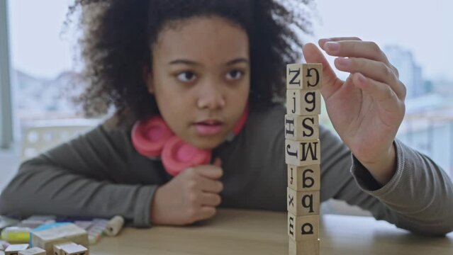 African American student doing activity playing block wooden for development together with enjoy and fun in the classroom.