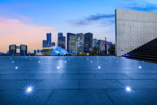 Empty square floor and city skyline with modern commercial buildings in Hangzhou at night, China.