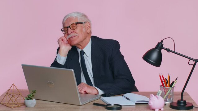 Senior businessman in thought and conjectures looking to side, dreaming, imagining something pleasant, fantasizing about weekends holidays. Elderly man isolated on pink studio background at office