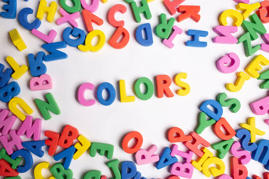Image of the Word color formed with colored letters and a group of single letters around them on a white background. 