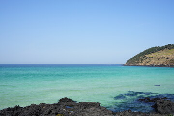 Fototapeta na wymiar rock beach and clear bluish sea