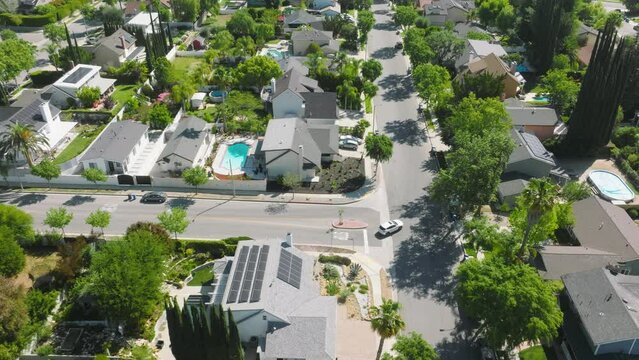 Drone Footage Of Luxury Residential Area In Los Angeles County, California, USA. White SUV Driving Along A Valley With Lush Greenery And High End Property As Seen From Above. High Quality 4k Footage