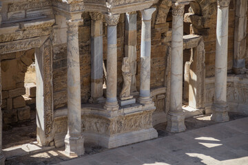 Fototapeta premium Turkey, Denizli, 29.08.2021: Ancient ruins of the Roman amphitheater in Hierapolis, Turkey. Statue and columns of the Colosseum. Ancient theater in Pamukkale. Travel in Turkey.