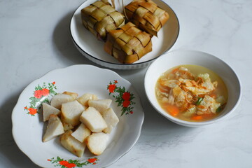 a plate of rice cake or ketupat served with vegetable soup