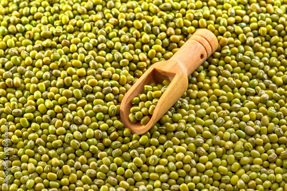 Wall mural mung beans and small wooden spoon background