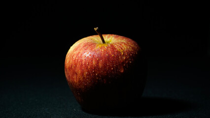 red apple on black background image captured at night 9 p.m. from well known restaurant in india. - obrazy, fototapety, plakaty