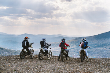 group motor travel offroad, motorcyclists standing on mountain top and taking pictures with phone,...