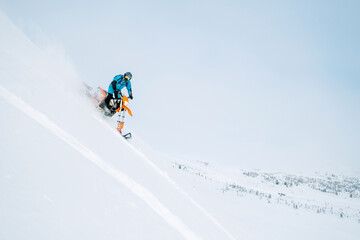 Winter sport outdoor. Male motorcyclist going down steep snowy slope riding snowbike dirt motorcycle
