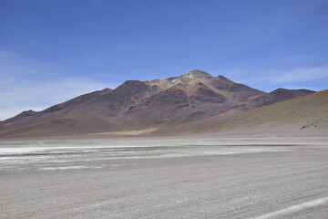 Lake between the mountains, with pink flamingo. Off-road tour on the salt flat Salar de Uyuni in Bolivia